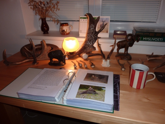 v loveckém pokoji  s teplým svařákem nad svými loveckými zápisky