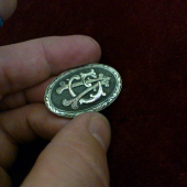 Striekorný medajlon s monogramom .