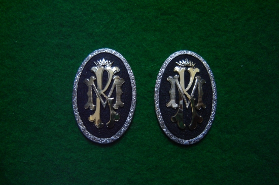 Striekorný medajlon so zlatým  monogramom .