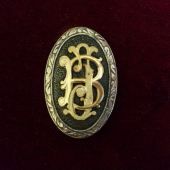 Striekorný medajlon so zlatým  monogramom na pištolovu rukoveť pažby.