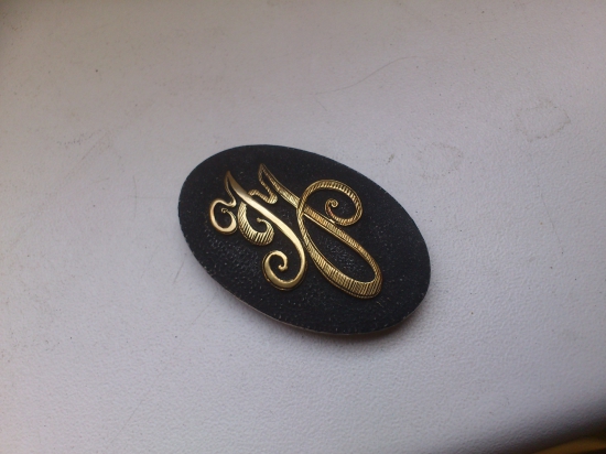 strieborný medajlon do pistolovej rukovete pažby, s písaným monogramom IJ..